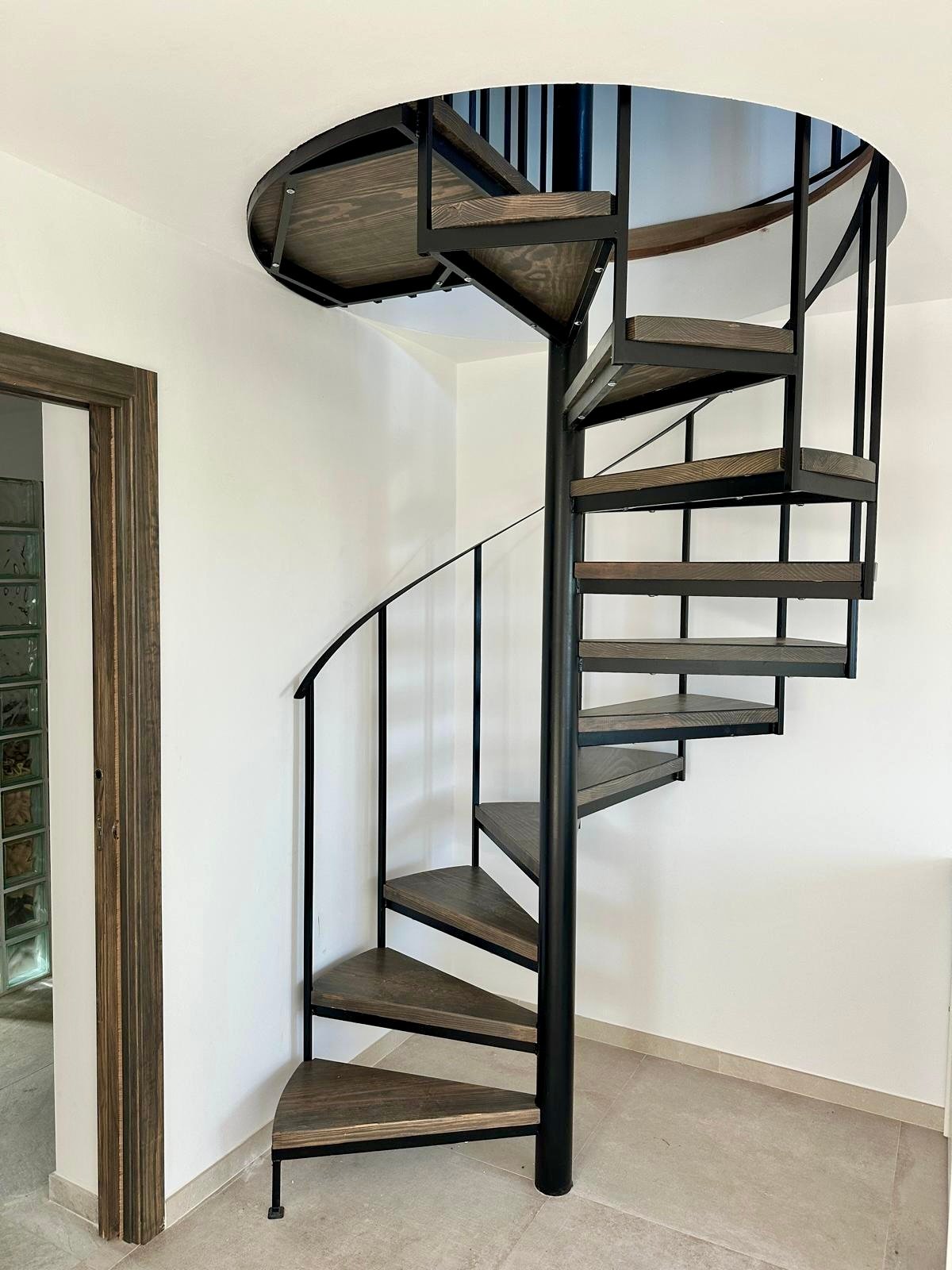 Schwarze Metall-Wendeltreppe mit Holzstufen, gefertigt für ein Landhaus in Cómpeta.